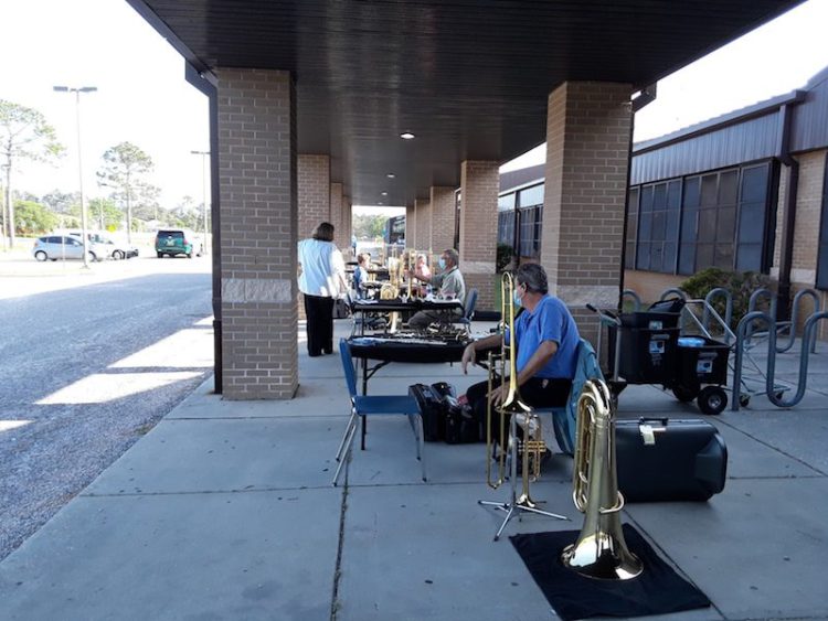 Schmidt’s Music employees (from closest to farthest) Michael Glenn, Joe Hooten, and Jeanie Harnish at an outdoor horn drive.